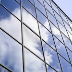 Blue sky reflecting on the windows of a business building