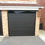 A black garage door on rollers